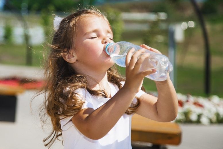 Little Girl Drinking Water From Plastic Bottle